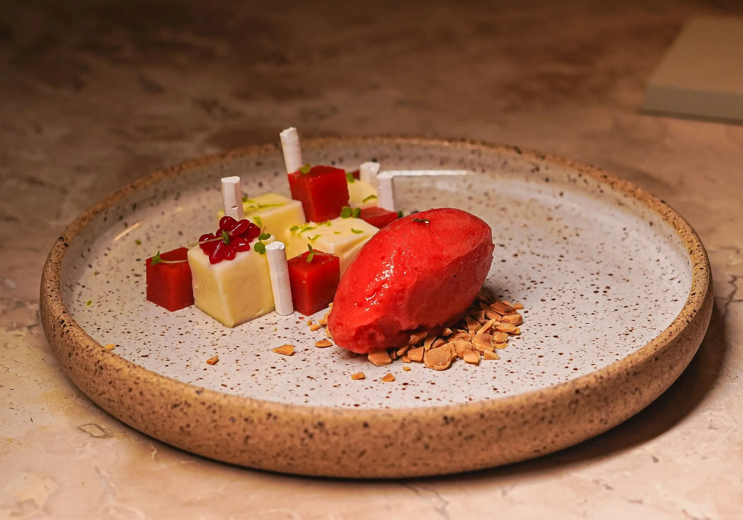 Dessert aux fruits rouges : sorbet, cubes de mousse et éclats d'amande