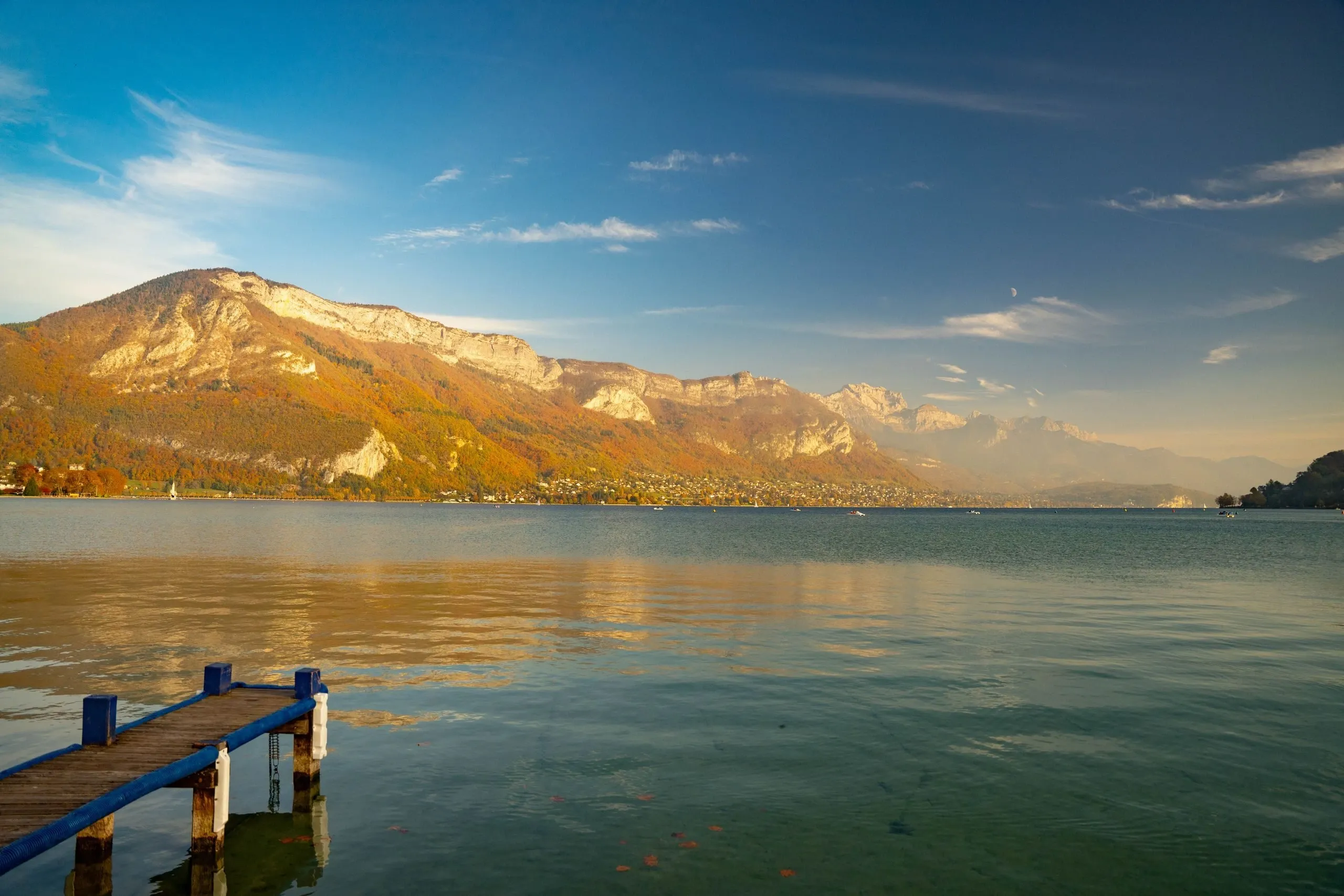 Le lac d'Annecy en automne, un ponton et les montagnes au soleil couchant